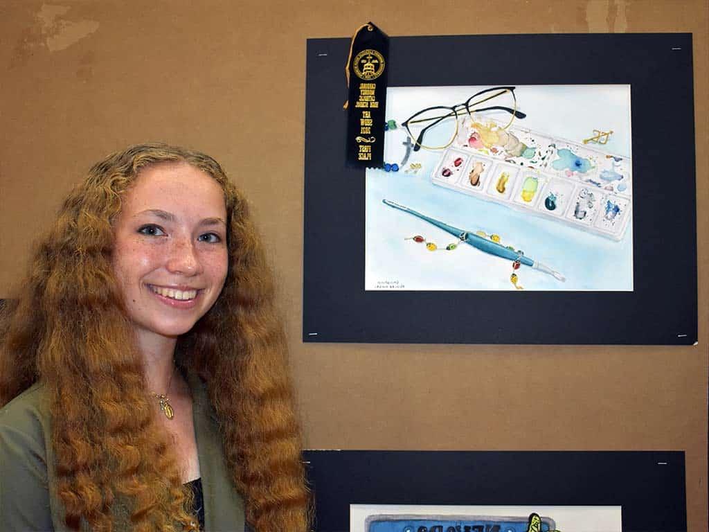 Art student posing with her art and ribbon